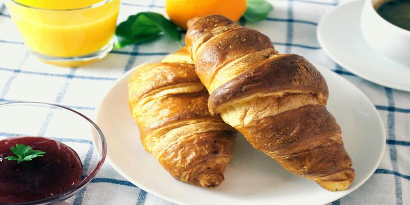 A plate of croissants and juice

Description automatically generated