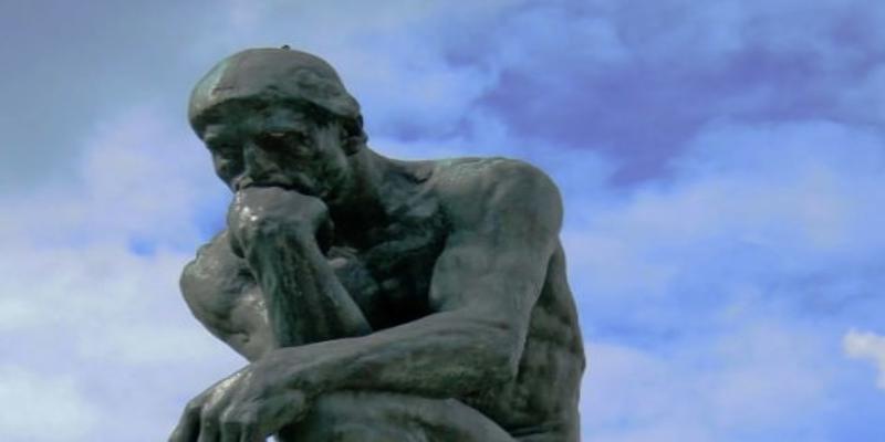 A statue of a person with his hands on his face
Description automatically generated